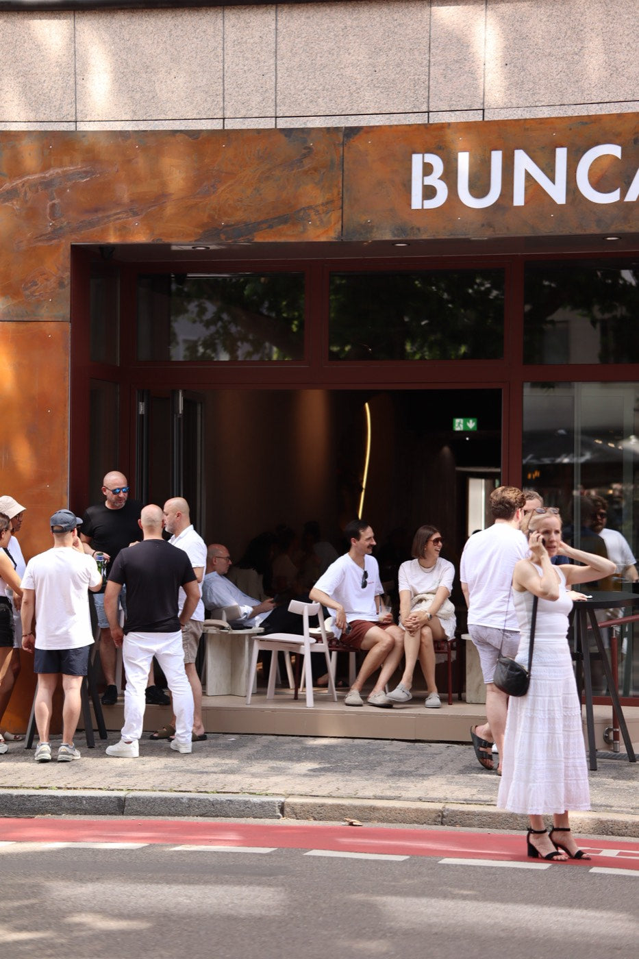 Gäste vor dem geöffneten Café an einem Sommertag